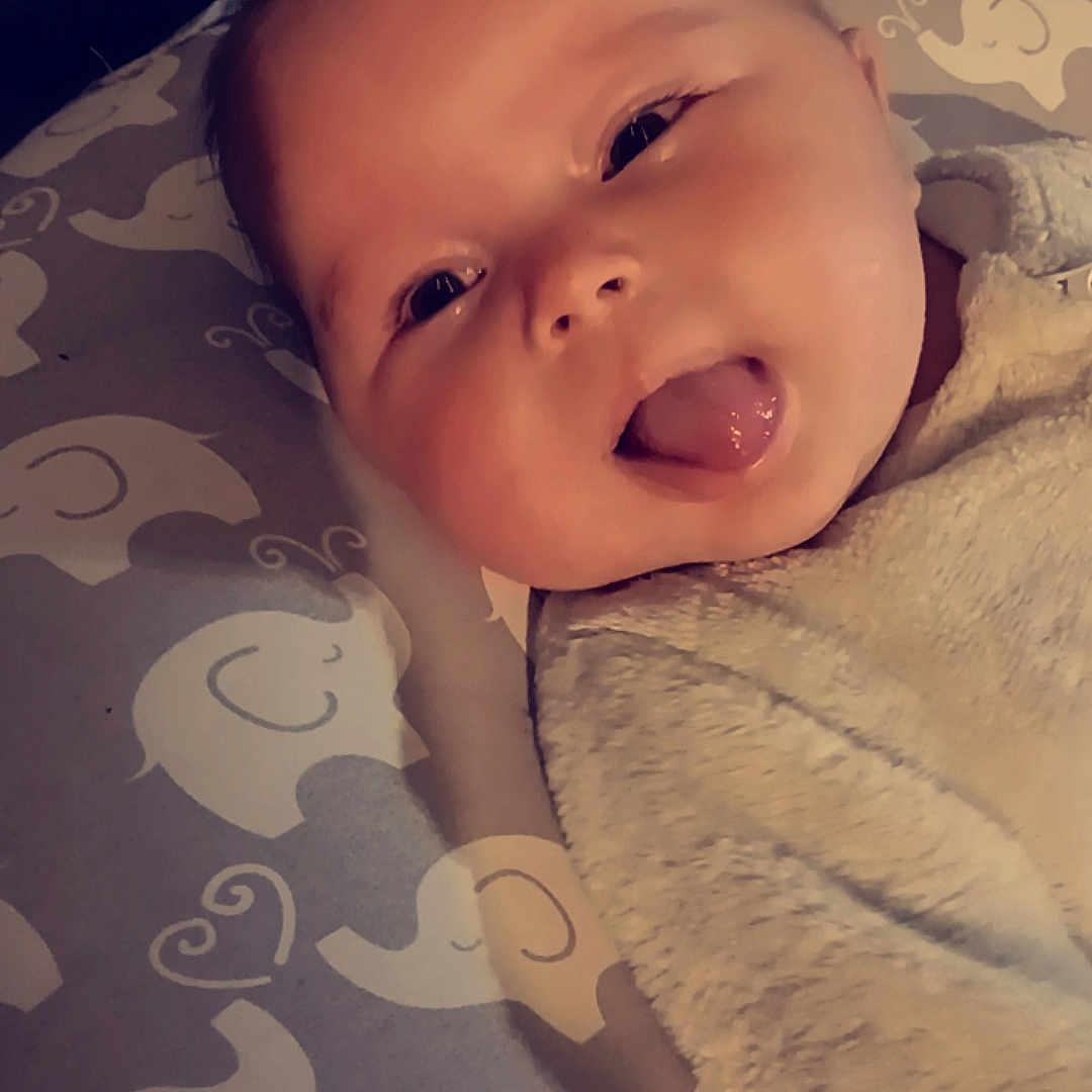 Mikenna joined the competition — help win amazing prizes! baby, babylaughing, blanket, bodypart, face, finger, hand, happy, head, laughing, mouth, newborn, person, photography, portrait, quilt, smile, tongue, towel