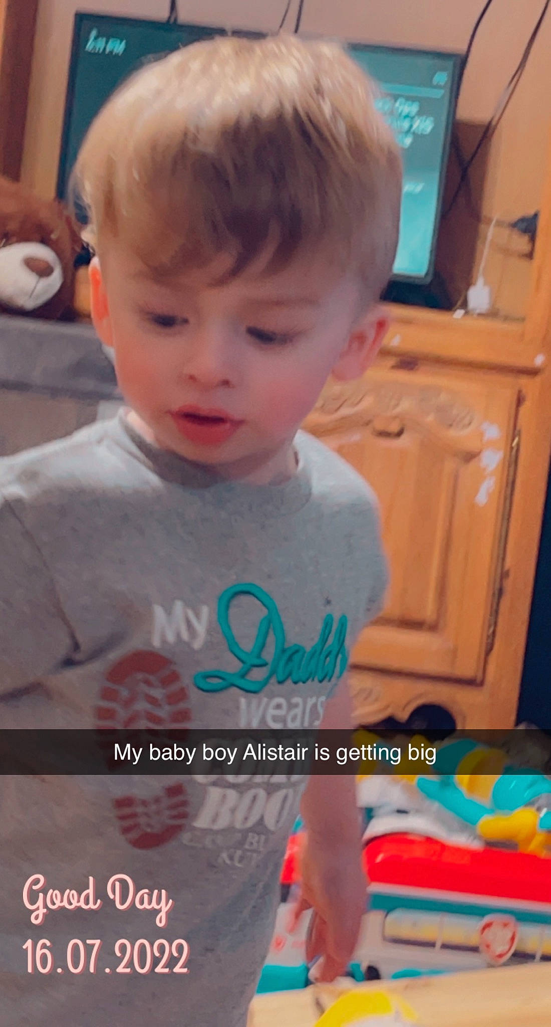 Alistair is registered to the contest to win money with this photo: blond, cabinetry, child, chin, electric_blue, eyelash, face, fun, hairstyle, happy, head, iris, nose, organ, person, photo_caption, publication, sleeve, t_shirt, television