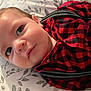baby, checkered_pattern, child, closeup, clothing, cute, expression, eyes, fabric, face, head, indoor, infant, lying_down, pillow, portrait, red_shirt, skin, suspenders, young_child