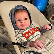 Xaidynn joined the competition — help win amazing prizes! baby, baby_rocker, blanket, casual, child, comfort, curious_expression, electronics, face, furniture, hands, headwear, hoodie, indoor, infant, person, seated, striped_clothing, television, young_child