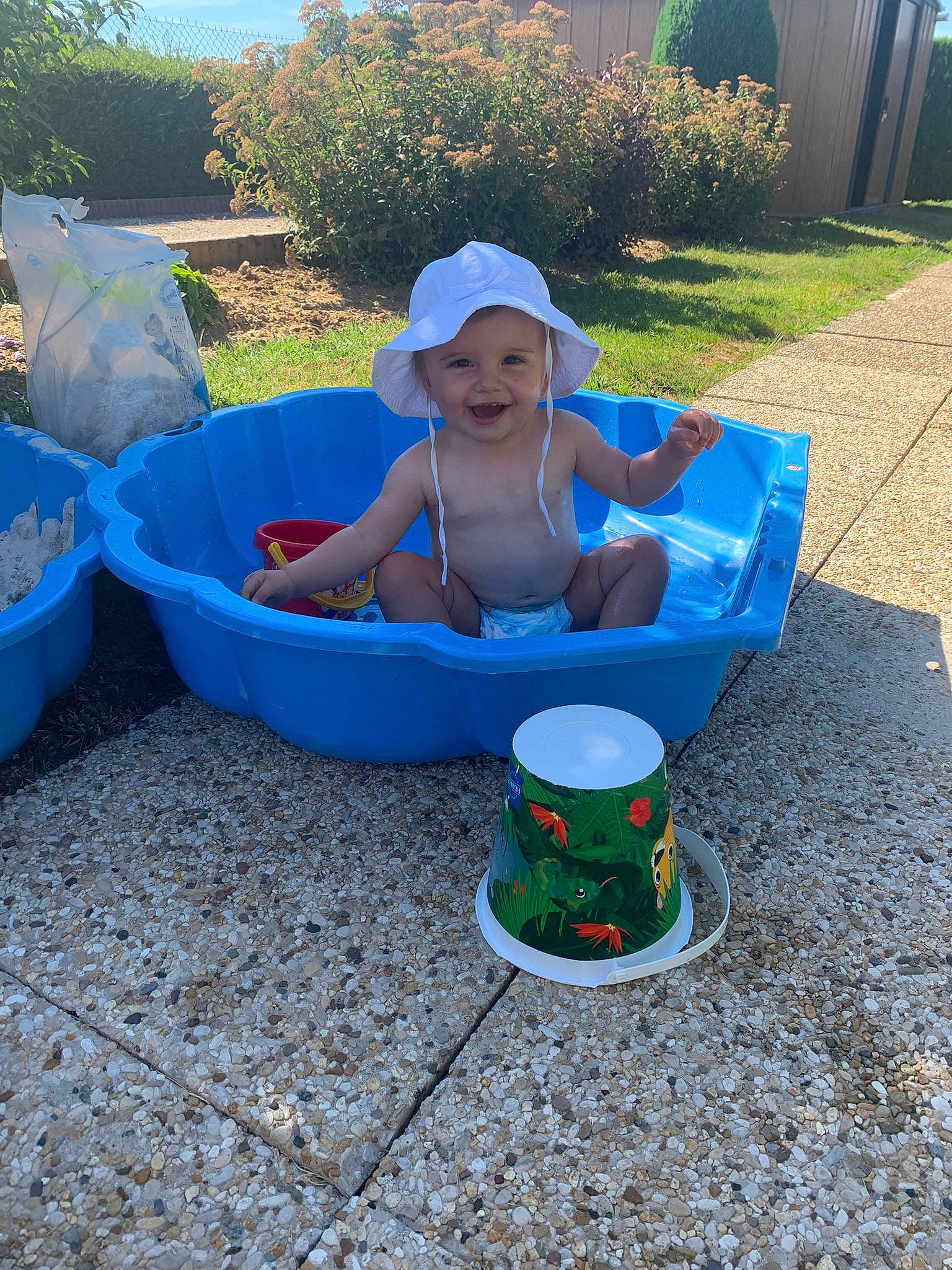 Jade a rejoint le concours — aidez-le/la à gagner de superbes lots ! baby, baby_toddler_clothing, blue, comfort, electric_blue, fun, grass, hat, headwear, joy, leisure, outdoor_furniture, outdoor_play_equipment, person, plant, plastic, play, recreation, shade, sitting