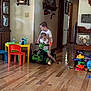 Mylin is registered to the contest to win money with this photo: child, children, indoor, toy, atv, ride, floor, wooden_floor, furniture, table, chair, toy_table, toy_chair, play, happy, smiling, person, living_room, home, fun