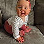 Isla is registered to the contest to win money with this photo: baby, child, couch, headband, pink_clothing, white_shirt, hands, feet, indoors, curious_expression, crawling, plush, soft_texture, smiling, portrait, human, infant, cute, cozy, home