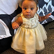 Germani is registered to the contest to win money with this photo: baby, carpet, child, closeup, cute, dress, elegant, expression, fashion, footwear, headwear, indoor, innocent, patterned_background, person, portrait, small_shoes, standing, white_bow, young_child