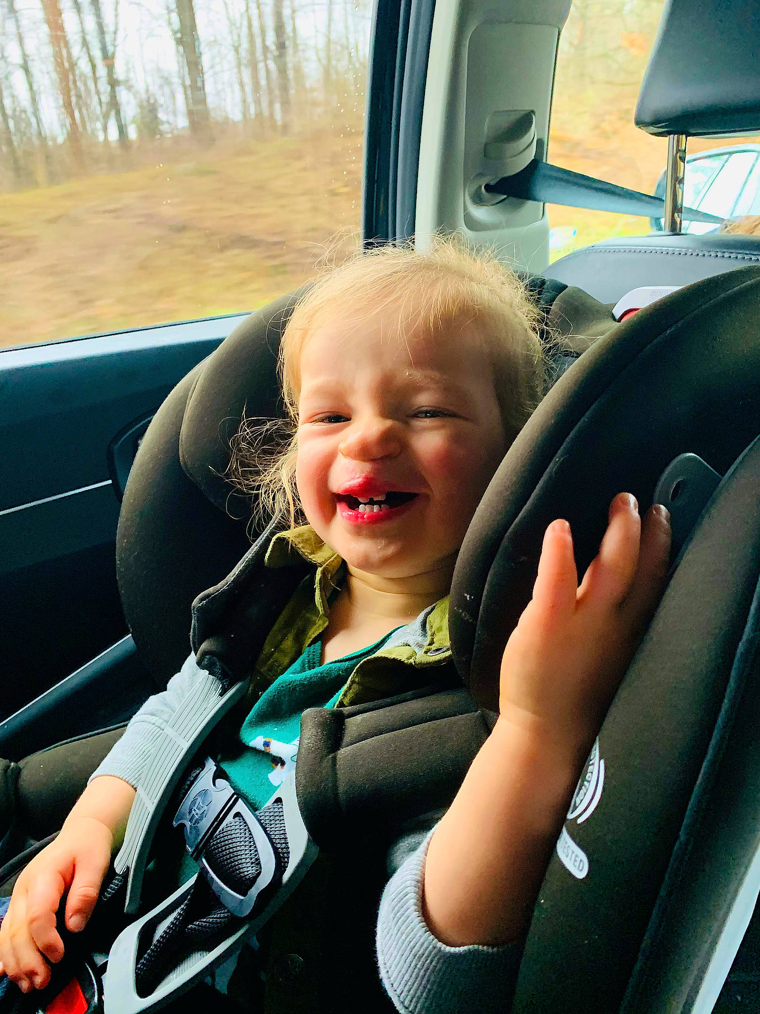 Ethan is registered to the contest to win money with this photo: auto_part, automotive_design, automotive_exterior, automotive_window_part, car, car_seat, car_seat_cover, family_car, head_restraint, mammal, motor_vehicle, person, plant, seat_belt, smile, steering_part, steering_wheel, toddler, vehicle, vehicle_door
