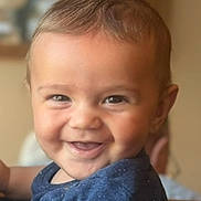 David is registered to the contest to win money with this photo: baby, smiling, child, indoor, blue_shirt, cute, portrait, happy, face, young_child, infant, person, light, blurred_background, closeup, skin, hair, seated, toddler, expression
