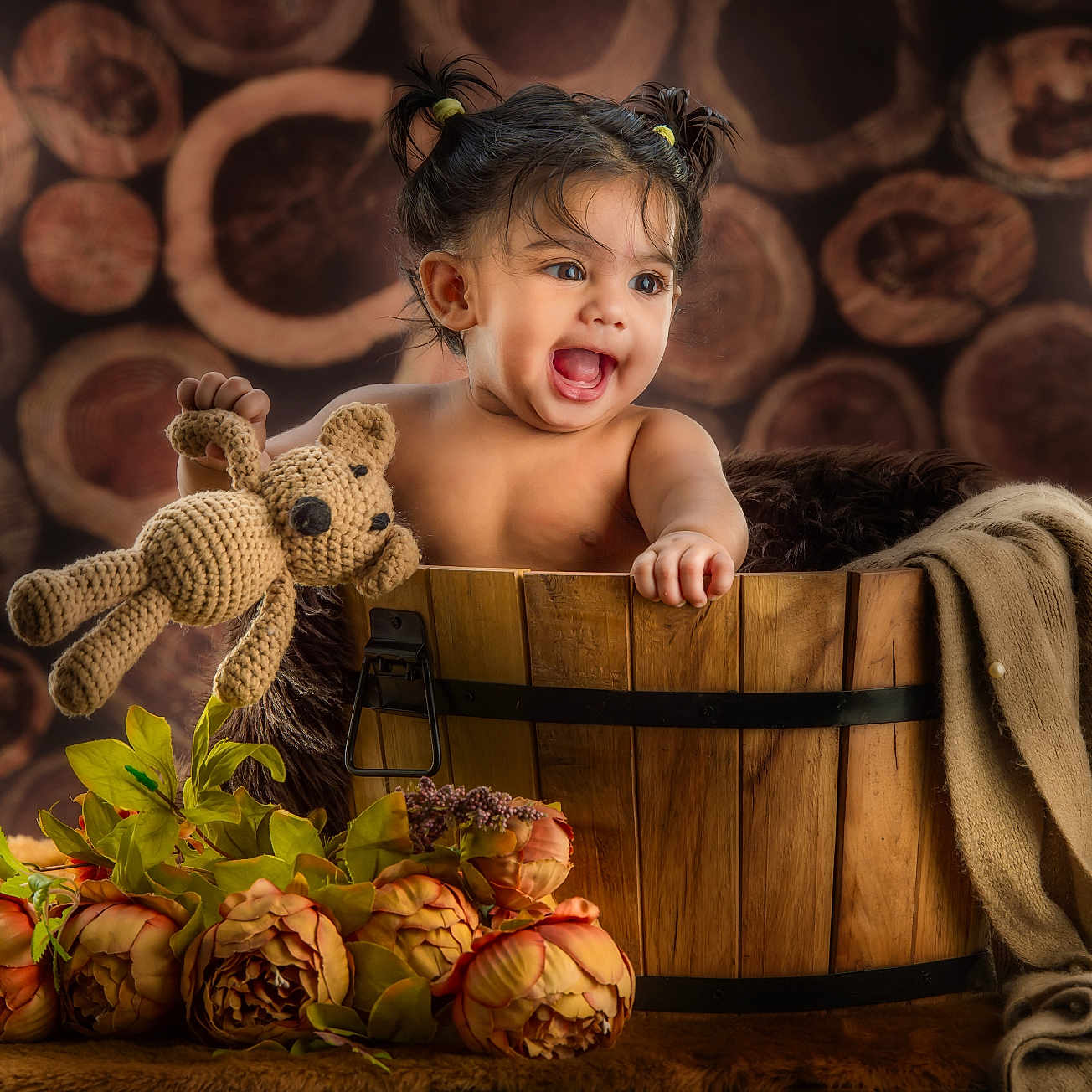 Sitara joined the competition — help win amazing prizes! toddler, child, baby, wooden_bucket, toy, crocheted_teddy, flowers, pigtails, smiling, happy, portrait, indoor, decorative, blanket, wood_background, cute, playful, young_child, warm_lighting, cozy