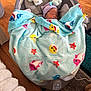 newborn, baby, blanket, baby_shark, sleeping, baby_rocker, toy, plush, hat, indoor, floor, wooden_floor, laundry_basket, cozy, peaceful, child, infant, colorful, soft_toy, nursery