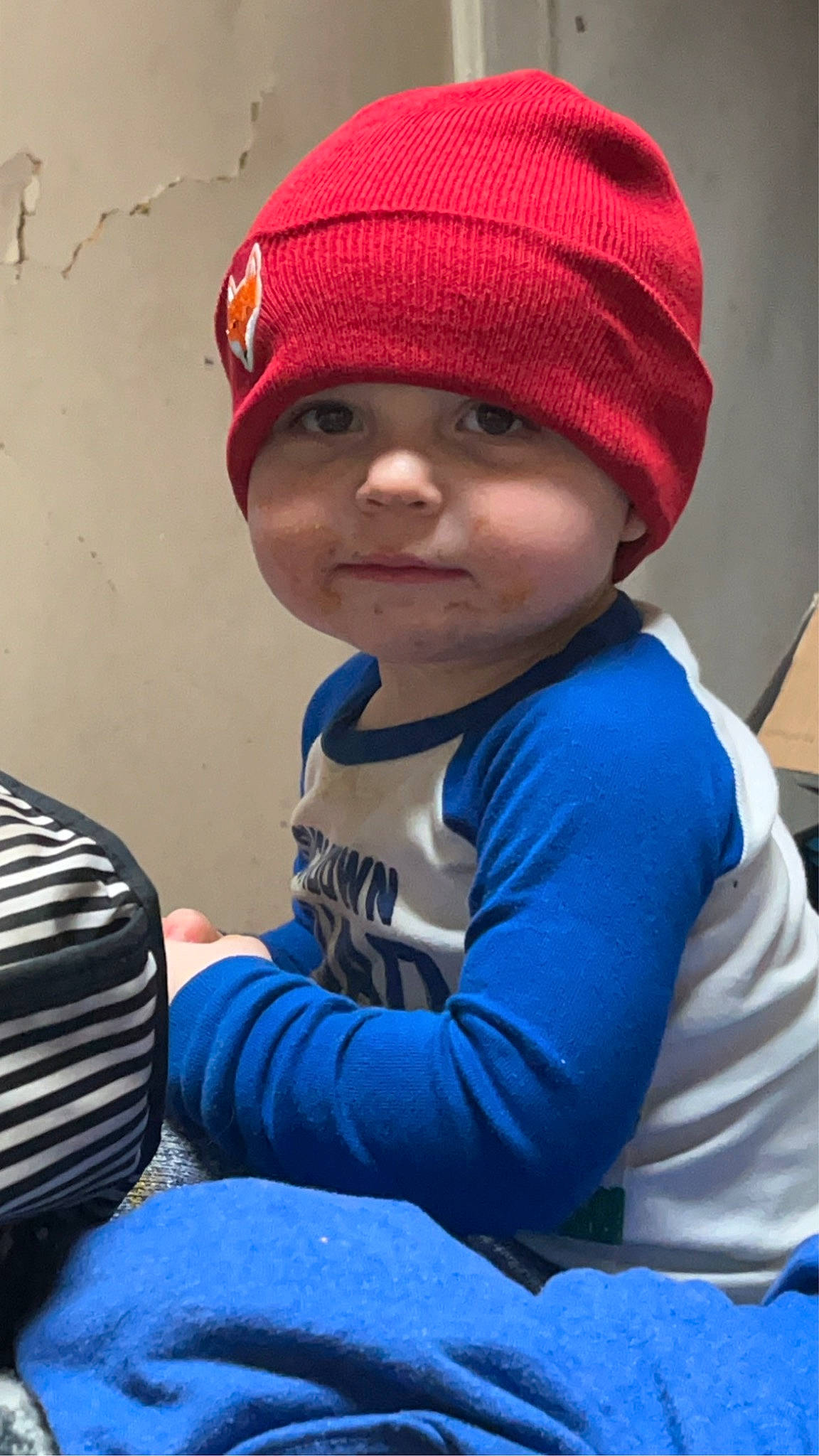 Chance is registered to the contest to win money with this photo: automotive_lighting, automotive_tire, baby, beanie, blue, bumper, cap, child, cool, electric_blue, fashion_accessory, fun, grille, headgear, headwear, hood, knit_cap, outerwear, person, personal_protective_equipment