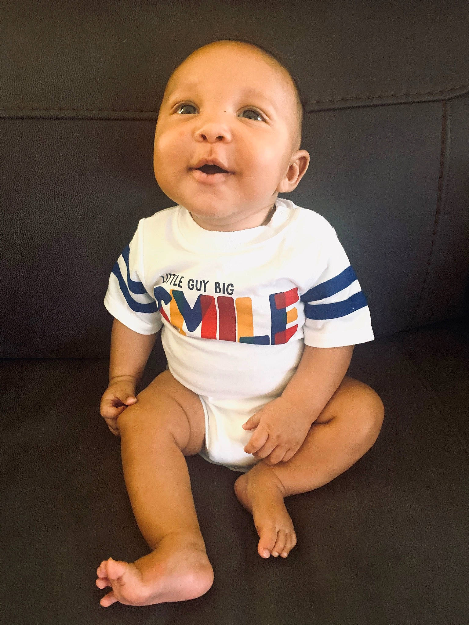 Huxley is registered to the contest to win money with this photo: baby, baby_toddler_clothing, cheek, child, chin, face, facial_expression, fun, head, leg, mouth, person, product, sitting, skin, sleeve, smile, standing, t_shirt, toddler