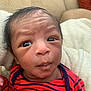 Amias is registered to the contest to win money with this photo: newborn, baby, infant, face, eyes, clothing, striped, red, navy, onesie, blanket, cozy, expression, curious, portrait, indoor, couch, person, head, skin