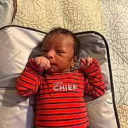Amias joined the competition — help win amazing prizes! baby, infant, onesie, striped_clothing, red_clothing, navy_clothing, face, hair, hand, fist, changing_pad, quilt, blanket, bed, lying_down, newborn, person, indoor, cute, portrait