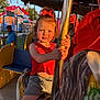 child, girl, carousel, amusement_park, ride, horse, red_bow, red_top, shorts, golden_pole, sunset_light, smile, person, outdoor, fun, carnival, colorful, attraction, happy, summer