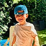 Ayden participe au concours pour gagner de l'argent avec cette photo : child, boy, smiling, cap, backward_cap, tshirt, outdoor, garden, greenery, sunlight, happy, portrait, person, daylight, chair, nature, young_child, casual_clothing, face, playful