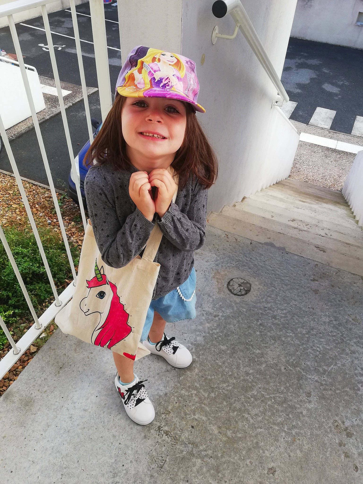 Léna participe au concours pour gagner de l'argent avec cette photo : asphalt, baseball_cap, cap, child, cool, denim, fashion_accessory, fence, footwear, fun, headwear, joy, leisure, pattern, person, pink, plant, recreation, sleeve, smile