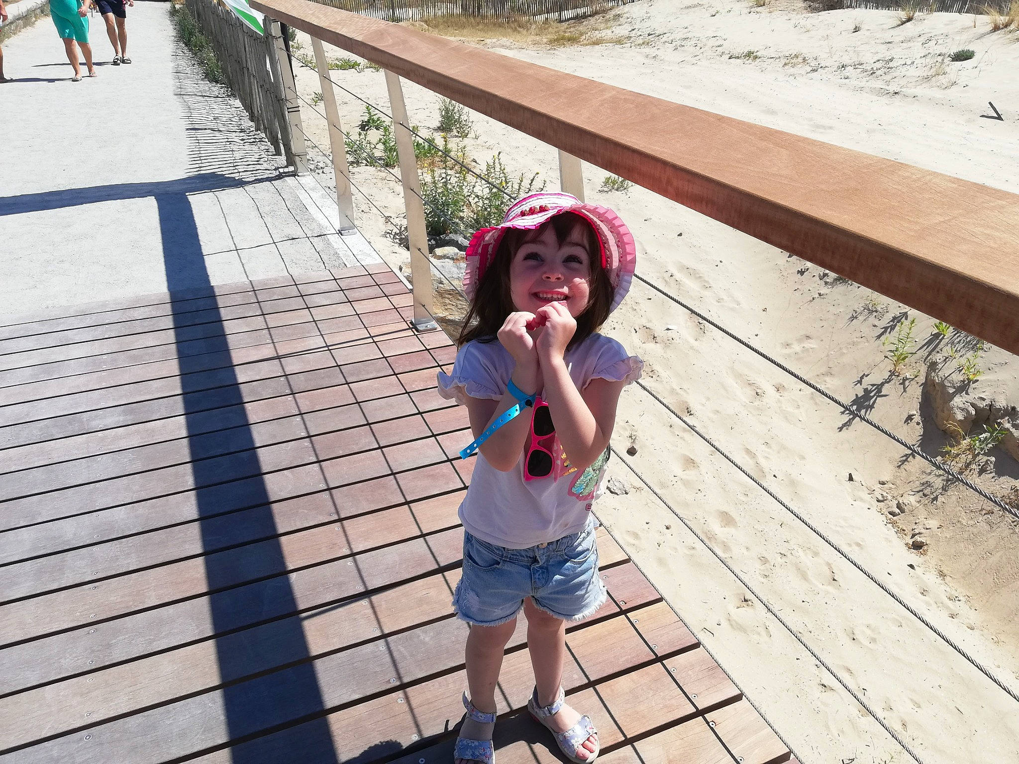 Léna participe au concours pour gagner de l'argent avec cette photo : baseball_cap, cap, fence, flooring, fun, happy, hat, joy, leg, leisure, line, morning, person, recreation, shorts, sidewalk, sun_hat, thigh, toddler, travel