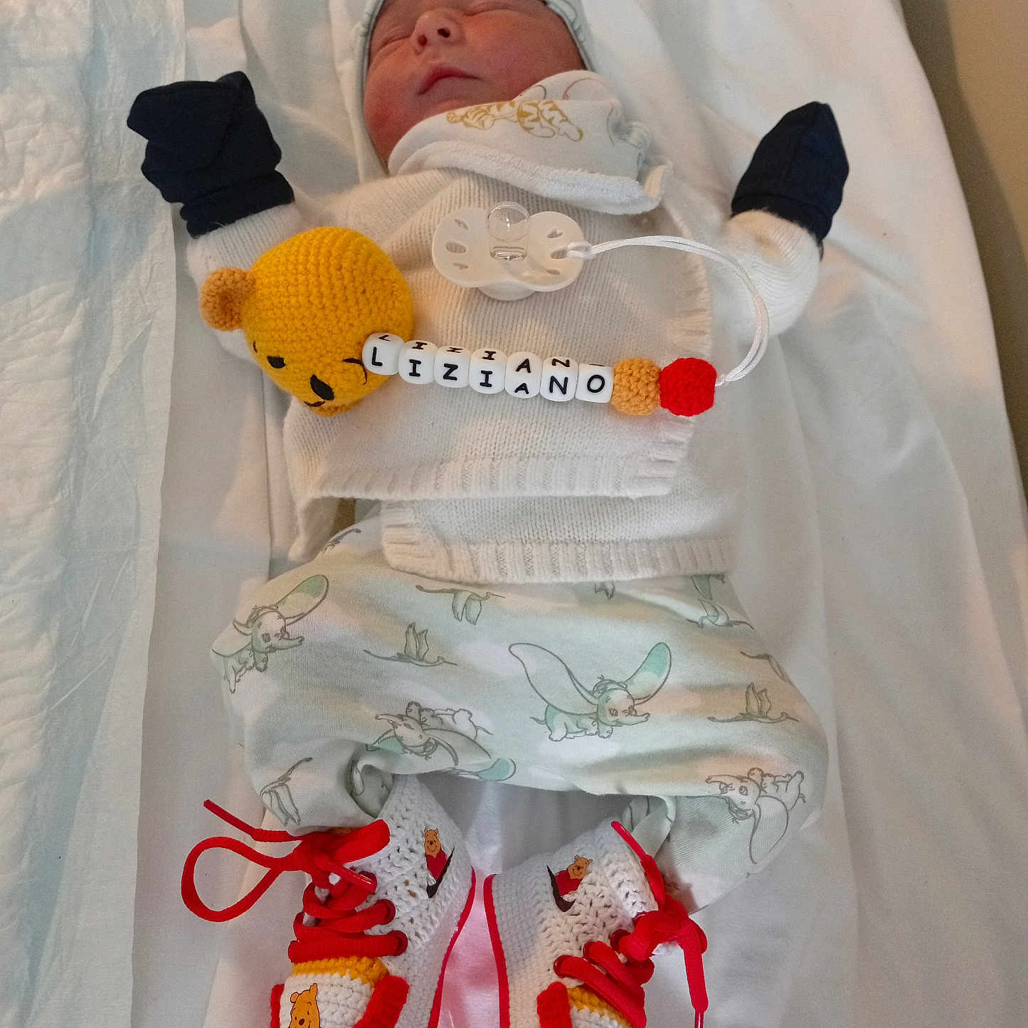 Liziano a rejoint le concours — aidez-le/la à gagner de superbes lots ! baby, baby_pants, beads, blanket, cozy, cute, hat, indoors, infant, knitted_shoes, lying_down, mittens, name_tag, newborn, pacifier, patterned_pants, sleeping, soft_lighting, white_clothing, winnie_the_pooh