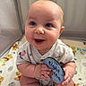 baby, infant, eight_months, smiling, blue_eyes, milestone_card, blanket, playpen, cute, happy, sitting, clothing, usa_flag, chubby_cheeks, hands, portrait, indoor, child, person, milestone