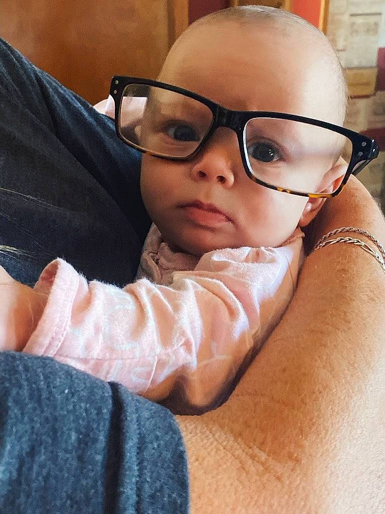 Kiana is registered to the contest to win money with this photo: baby, cheek, child, comfort, eyelash, eyewear, finger, gadget, gesture, hand, happy, mouth, nose, person, personal_protective_equipment, room, shoulder, sitting, thumb, toddler