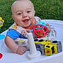 baby, smiling, walker, toy, ball, outdoor, grass, greenery, child, happy, playful, infant, cute, person, sitting, bright, daylight, clothing, bib, foot