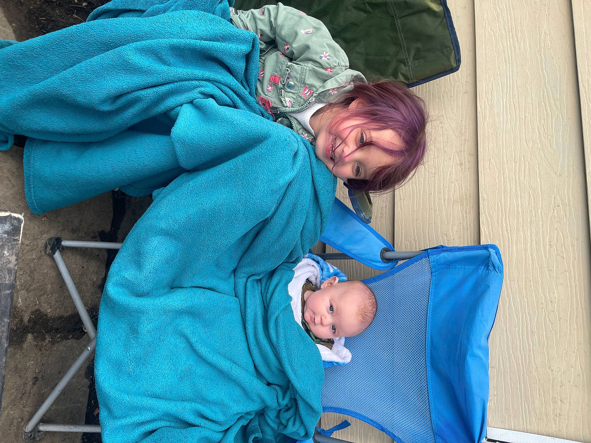 Mila is registered to the contest to win money with this photo: baby, baby_products, baby_toddler_clothing, child, comfort, electric_blue, grass, joy, lap, leisure, person, photograph, product, sitting, smile, snapshot, toddler, vacation, winter