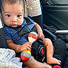 baby, infant, car_seat, toy, maraca, blue_shirt, seatbelt, car_interior, child, sitting, blanket, hand, foot, safety, cute, looking_at_camera, striped_clothing, young_child, indoors, closeup