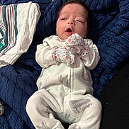 Sawyer joined the competition — help win amazing prizes! newborn, baby, infant, onesie, mittens, blanket, sleepy, lying_down, soft_fabric, plush, cozy, indoor, child, cute, face, person, clothing, resting, home, comfort