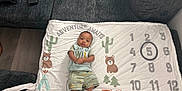 Ahmyus joined the competition — help win amazing prizes! baby, infant, blanket, milestone_blanket, numbers, circled_number, fox, bear, trees, cactus, clothing, socks, green_outfit, couch, floor, wood_floor, person, indoor, smiling, baby_bib