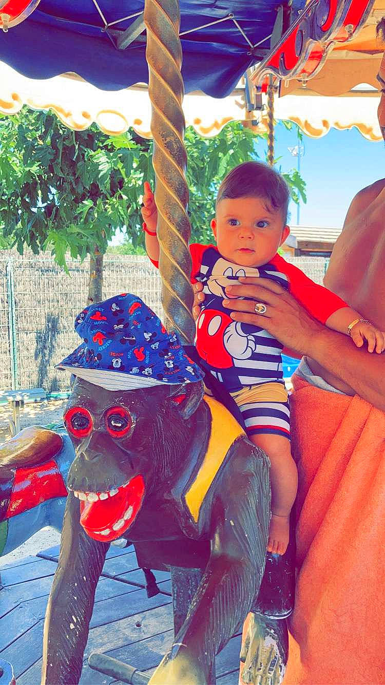 Liam a rejoint le concours — aidez-le/la à gagner de superbes lots ! amusement_ride, carousel, child, event, fun, happy, leisure, mammal, nonbuilding_structure, outdoor_play_equipment, person, playground, recreation, red, shorts, sitting, snapshot, swing, t_shirt, thigh