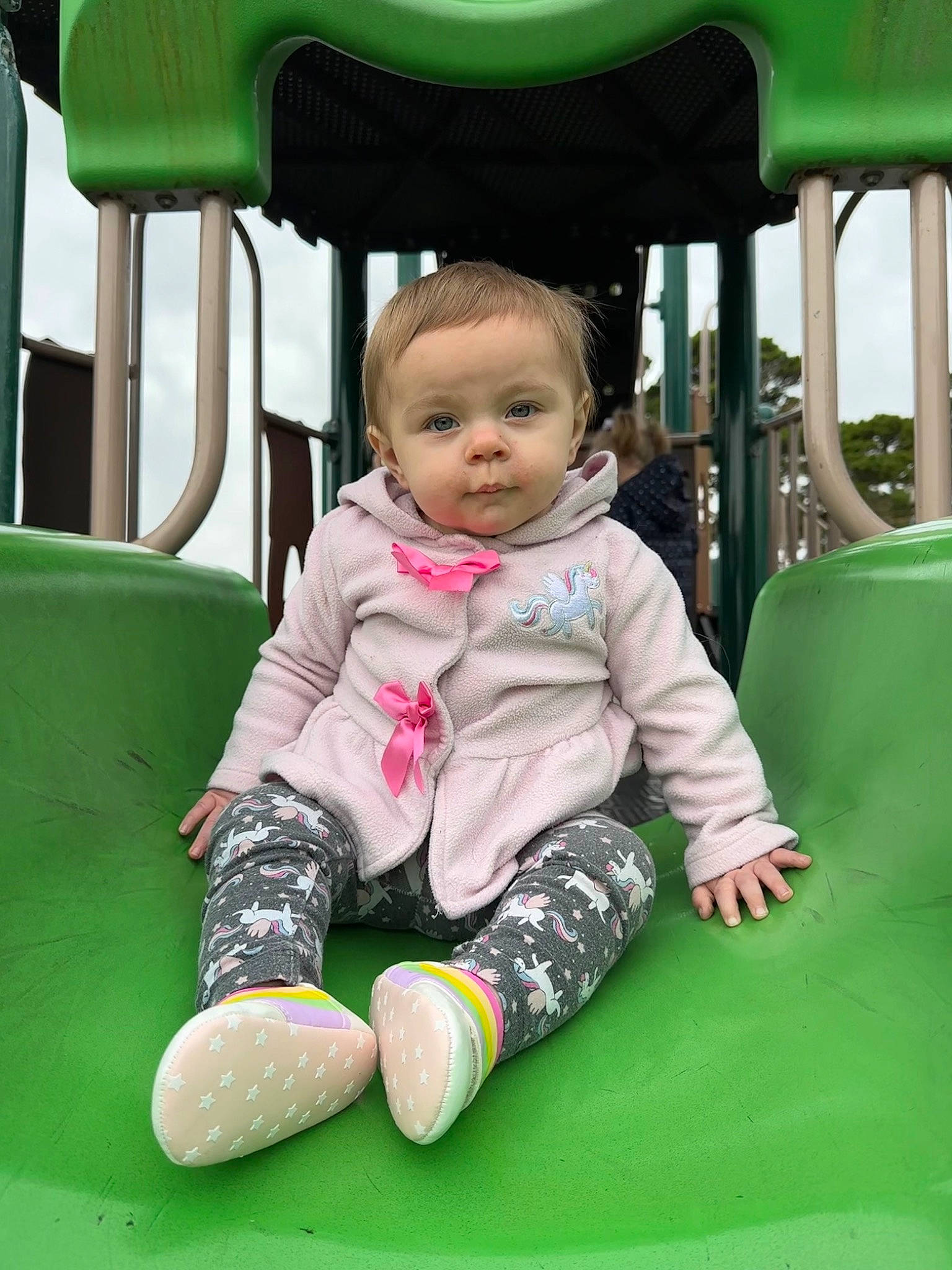 Aleyah is registered to the contest to win money with this photo: baby, baby_toddler_clothing, cheek, child, city, facial_expression, fun, grass, green, leisure, outdoor_play_equipment, person, play, playground, recreation, sitting, skin, sleeve, toddler, white
