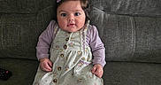 Mia joined the competition — help win amazing prizes! baby, child, toddler, girl, sitting, couch, gray_couch, dress, floral_dress, purple_hair_clip, brown_shoes, white_tights, indoors, portrait, cute, smiling, person, young_child, furniture, home