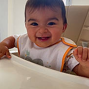 Nahël a rejoint le concours — aidez-le/la à gagner de superbes lots ! baby, smiling, high_chair, bib, indoor, child, happy, face, person, feeding, table, window, light, clothing, young_child, cute, infant, expression, sitting, home