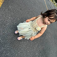 Alaia joined the competition — help win amazing prizes! toddler, child, dress, flower, road, asphalt, shoes, sparkly, cute, standing, bracelet, hair, side_view, outdoor, curious, expression, person, young_child, daylight, fashion