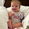 Marlow is registered to the contest to win money with this photo: baby, beads, bed, child, clothing, cute, face, foot, hair, hand, happy, indoors, infant, pillow, portrait, sitting, skin, smiling, toy, white