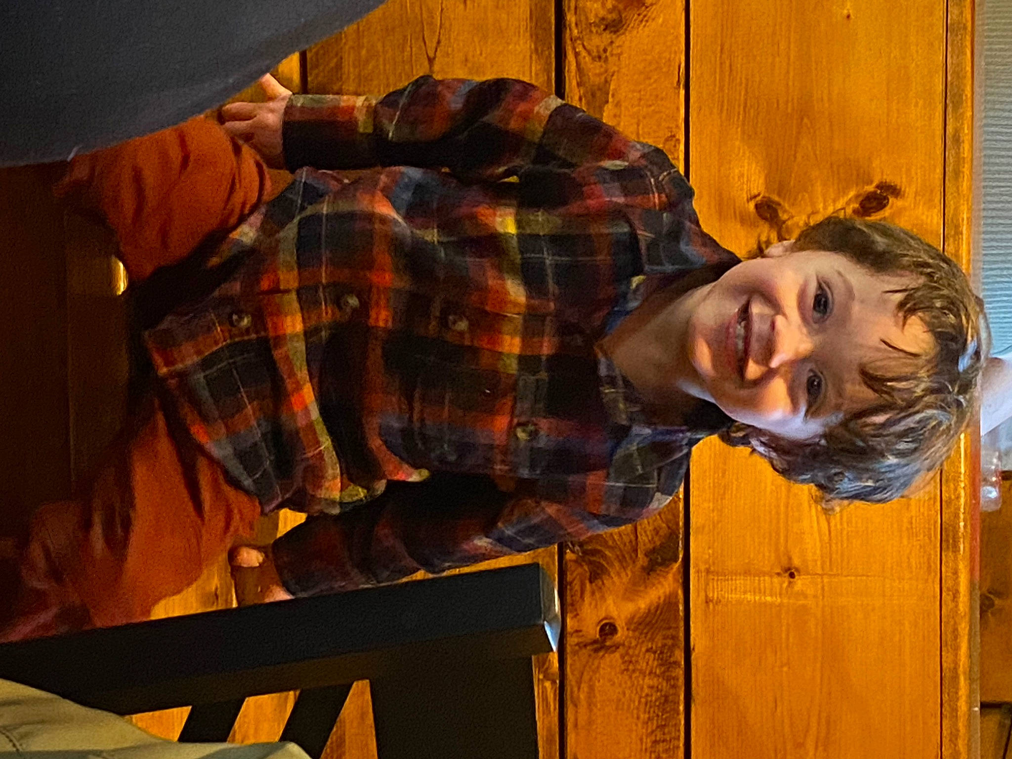 Stellan is registered to the contest to win money with this photo: child, electric_blue, flash_photography, fun, happy, joy, orange, pattern, person, plaid, portrait_photography, sitting, smile, tartan, wood