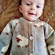 Lino participe au concours pour gagner de l'argent avec cette photo : baby, child, smiling, face, sweater, sheep_pattern, buttoned_clothing, blanket, soft_texture, portrait, indoor, cute, infant, happy, lying_down, warm_clothing, cozy, closeup, head, person