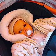 Rosalie a rejoint le concours — aidez-le/la à gagner de superbes lots ! baby, infant, pacifier, fur_lined_hood, beanie, winter_coat, floral_pattern, stroller, car_seat, closeup, portrait, blue_eyes, bundled_up, cozy, cute, skin, jacket, blanket, onesie, gaze