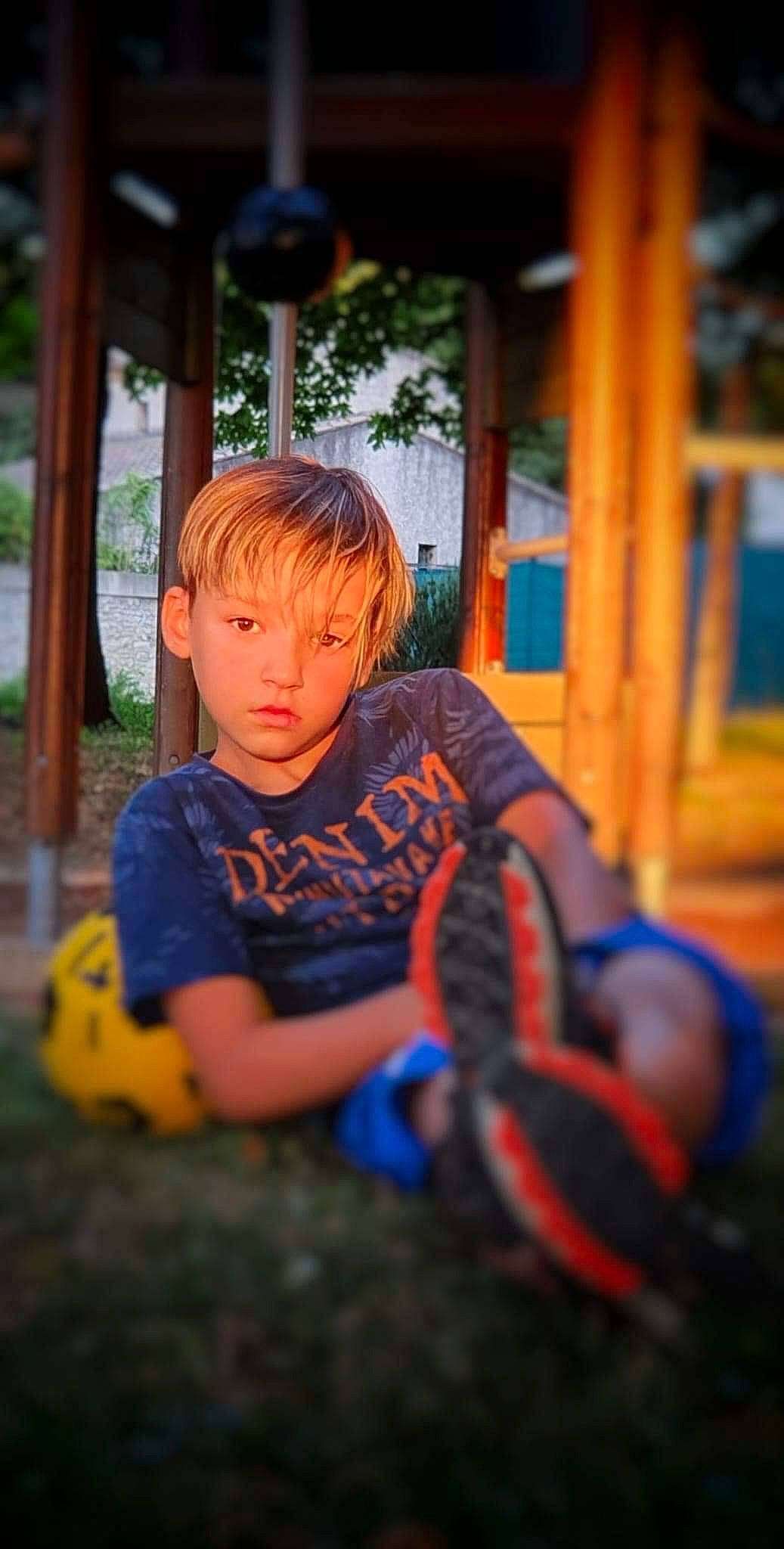 Ethan a rejoint le concours — aidez-le/la à gagner de superbes lots ! automotive_tire, child, electric_blue, fun, grass, hairstyle, happy, leisure, orange, outdoor_play_equipment, person, plant, playground, recreation, shorts, sitting, swing, t_shirt, toddler, tree