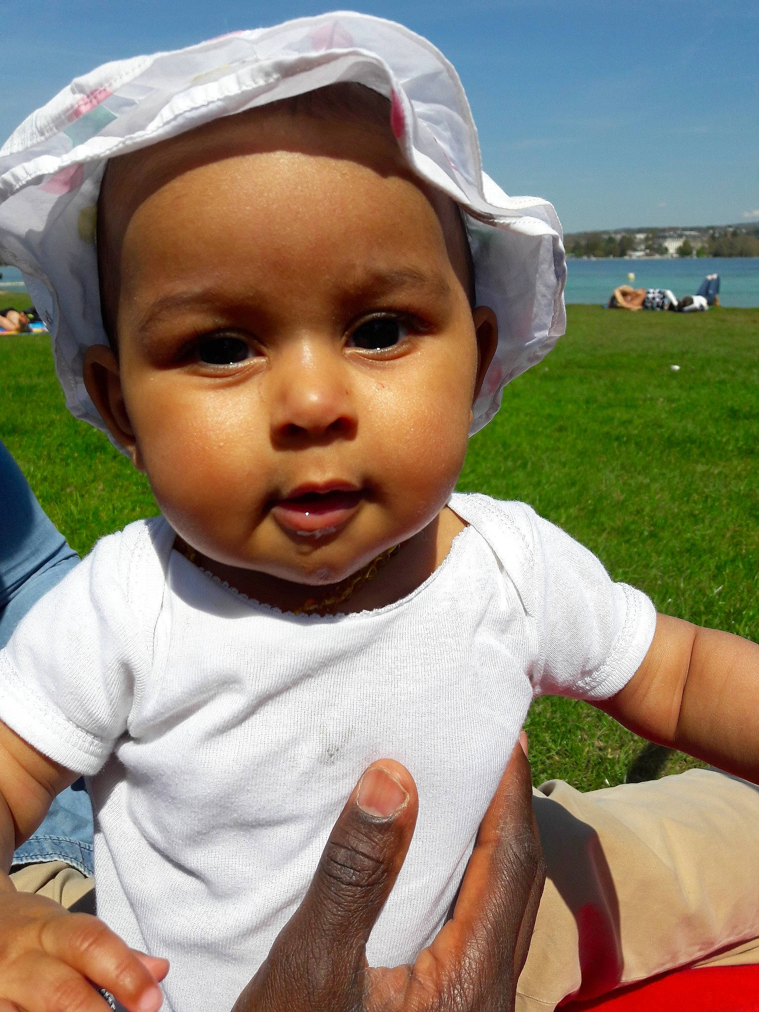 Rosa a rejoint le concours — aidez-le/la à gagner de superbes lots ! baby, cheek, child, facial_expression, grass, happy, head, headgear, lip, person, skin, smile, sun_hat, toddler