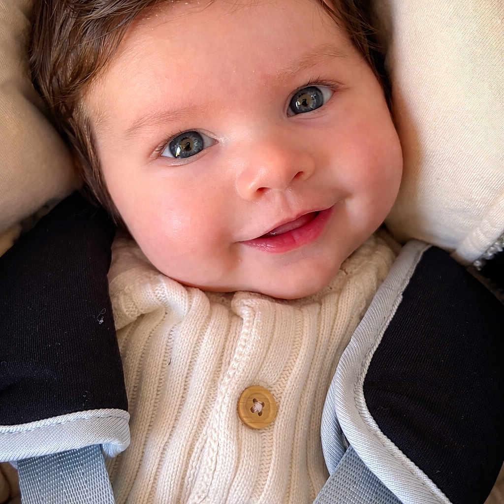 Léon participe au concours pour gagner de l'argent avec cette photo : baby, smiling, face, eyes, knit_sweater, button, car_seat, straps, child, infant, closeup, portrait, cute, happy, cozy, clothing, seat_belt, head, baby_fashion, indoors