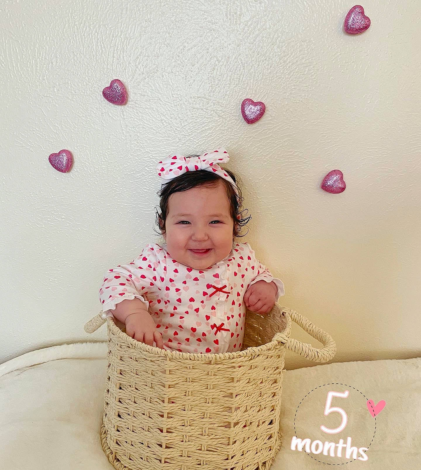 Angelina is registered to the contest to win money with this photo: baby, baby_toddler_clothing, basket, child, circle, event, fashion_accessory, fun, happy, home_accessories, joy, magenta, pattern, people_in_nature, person, pink, sitting, sleeve, smile, storage_basket