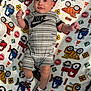 baby, child, infant, blanket, clothing, nike, shoes, footwear, pattern, cartoon, vehicle, toy, fabric, cute, portrait, lying_down, indoor, colorful, person, socks