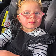 Camelia participe au concours pour gagner de l'argent avec cette photo : toddler, child, glasses, car_seat, seatbelt, striped_shirt, black_overall, pigtails, sunlight, portrait, face, indoor, car_interior, young_child, cute, person, eyewear, sitting, safety, closeup