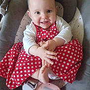 Théa a rejoint le concours — aidez-le/la à gagner de superbes lots ! baby, baby_seat, child, clapping_hands, clothing, comfort, cute, expression, face, foot, hand, happy, indoors, infant, joyful, person, polka_dot, red_dress, seat, smiling