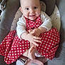 baby, baby_seat, child, clapping_hands, clothing, comfort, cute, expression, face, foot, hand, happy, indoors, infant, joyful, person, polka_dot, red_dress, seat, smiling