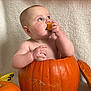 Emmie joined the competition — help win amazing prizes! baby, pumpkin, halloween, orange, child, cute, holiday, decoration, fall, festive, costume, sitting, infant, chewing, face, skin, legs, hand, background, tape