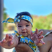 Emma a rejoint le concours — aidez-le/la à gagner de superbes lots ! baby, child, headband, blue_sky, outdoor, hand, person, smiling, portrait, tattoo, clothing, cute, skin, face, arm, holding, summer, daylight, cheerful, infant