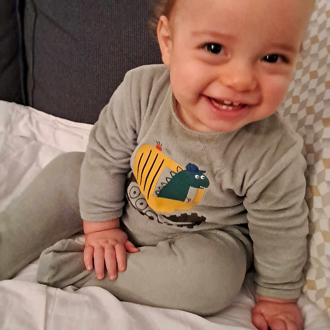 Hugo participe au concours pour gagner de l'argent avec cette photo : baby, babylaughing, bed, clothing, couch, cushion, face, furniture, happy, head, homedecor, indoors, laughing, pants, person, photography, portrait, sitting, smile, t_shirt