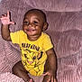 baby, child, smiling, yellow_shirt, cartoon_character, lion, plush_chair, pink, happy, sitting, indoors, cute, face, hand, feet, person, toddler, clothing, wall, carpet