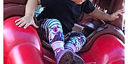 Cheyanne joined the competition — help win amazing prizes! toddler, child, playground, slide, curly_hair, black_shirt, floral_leggings, outdoor, play, toy, red, plastic, little_tikes, fun, adventure, person, feet, hand, daylight, activity